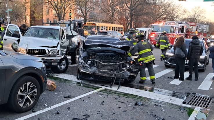 FDNY firefighters respond to a multi-vehicle car accident in New York City with severely damaged vehicles and debris scattered across the intersection