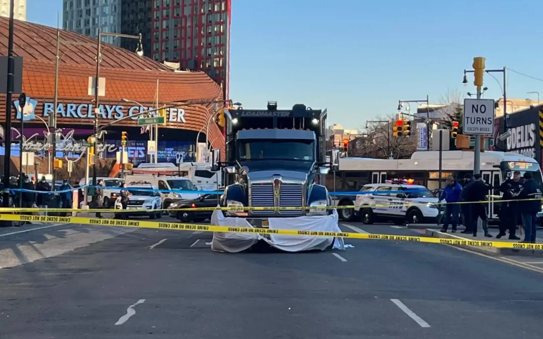 Dump truck stopped behind police tape after a crash on Atlantic Avenue near Barclays Center in Brooklyn, with NYPD officers at the scene